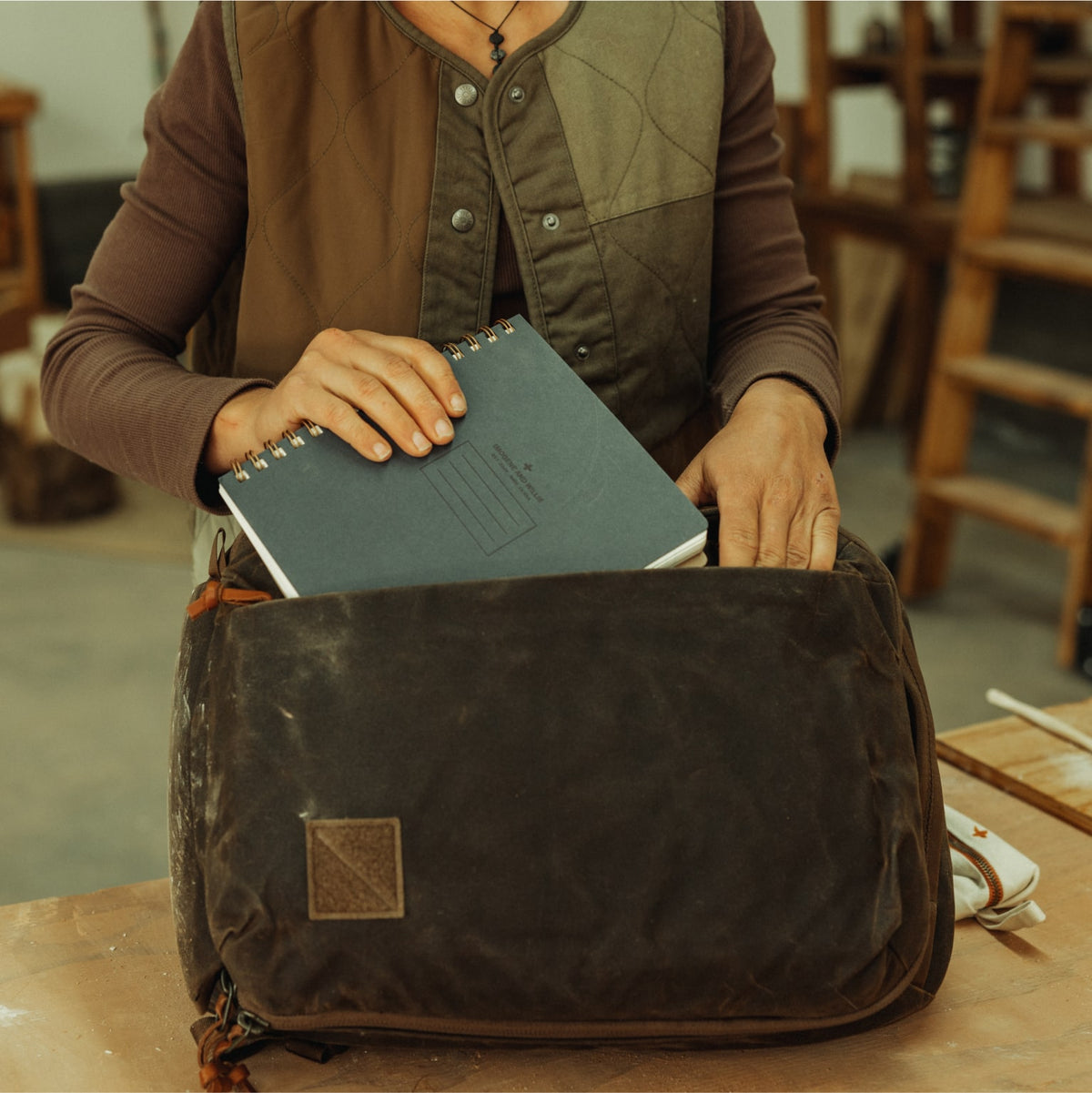 CIVIC Panel Loader 16L in waxed tan - packing the side access pocket with a notebook. CIVIC Panel Loader 16L in waxed tan - packing the side access pocket with a notebook. [13016cc-WTN