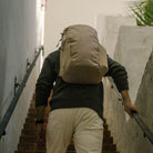 Person with a CIVIC Half Zip 22L in Fossil Brown backpack climbing stairs in an urban setting Person with a CIVIC Half Zip 22L in Fossil Brown backpack climbing stairs in an urban setting [13003d-FBN