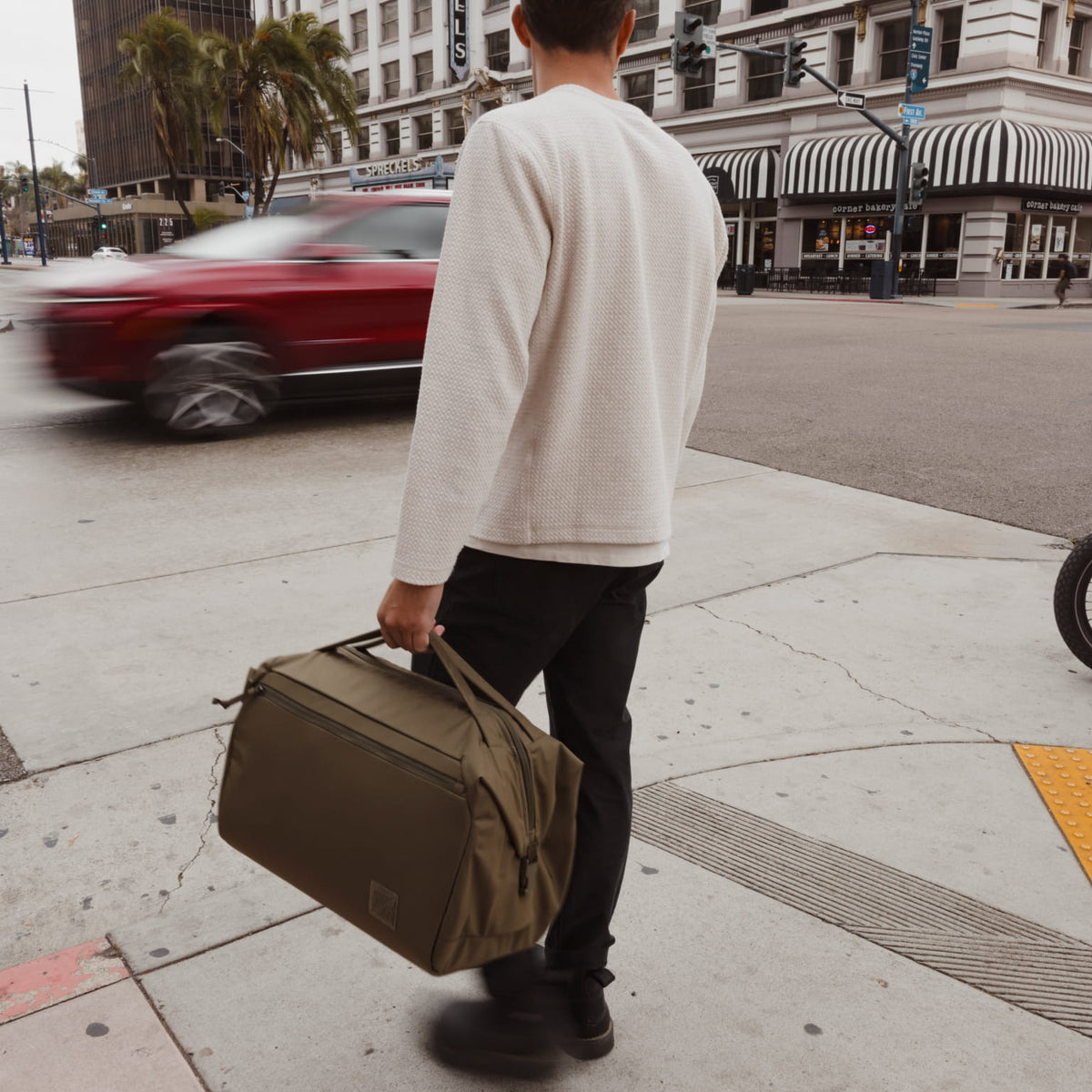 Transit Duffel 35L in OD Green street crossing [13014d-ODG]